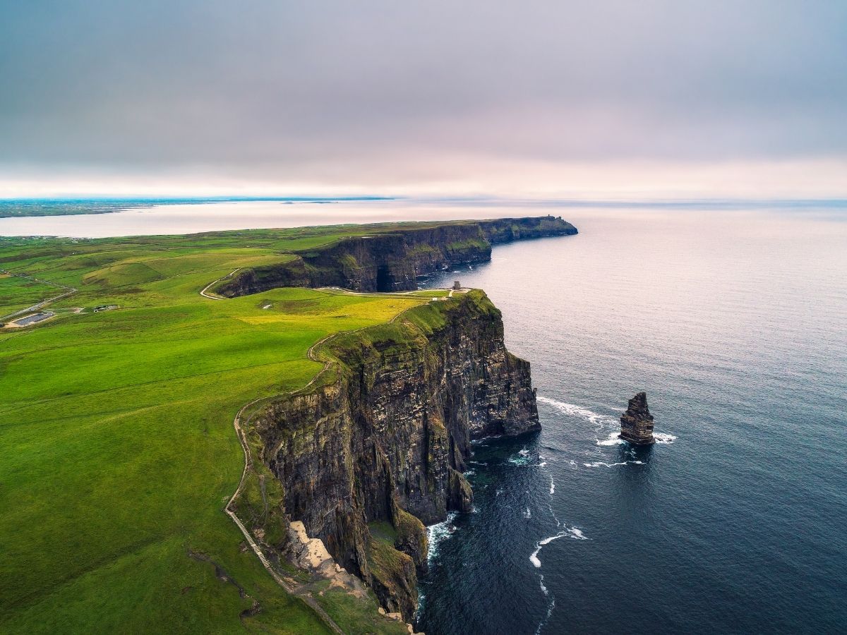 Cliffs of Moher and green countryside with prepaid travel eSIM providing reliable mobile data connectivity.